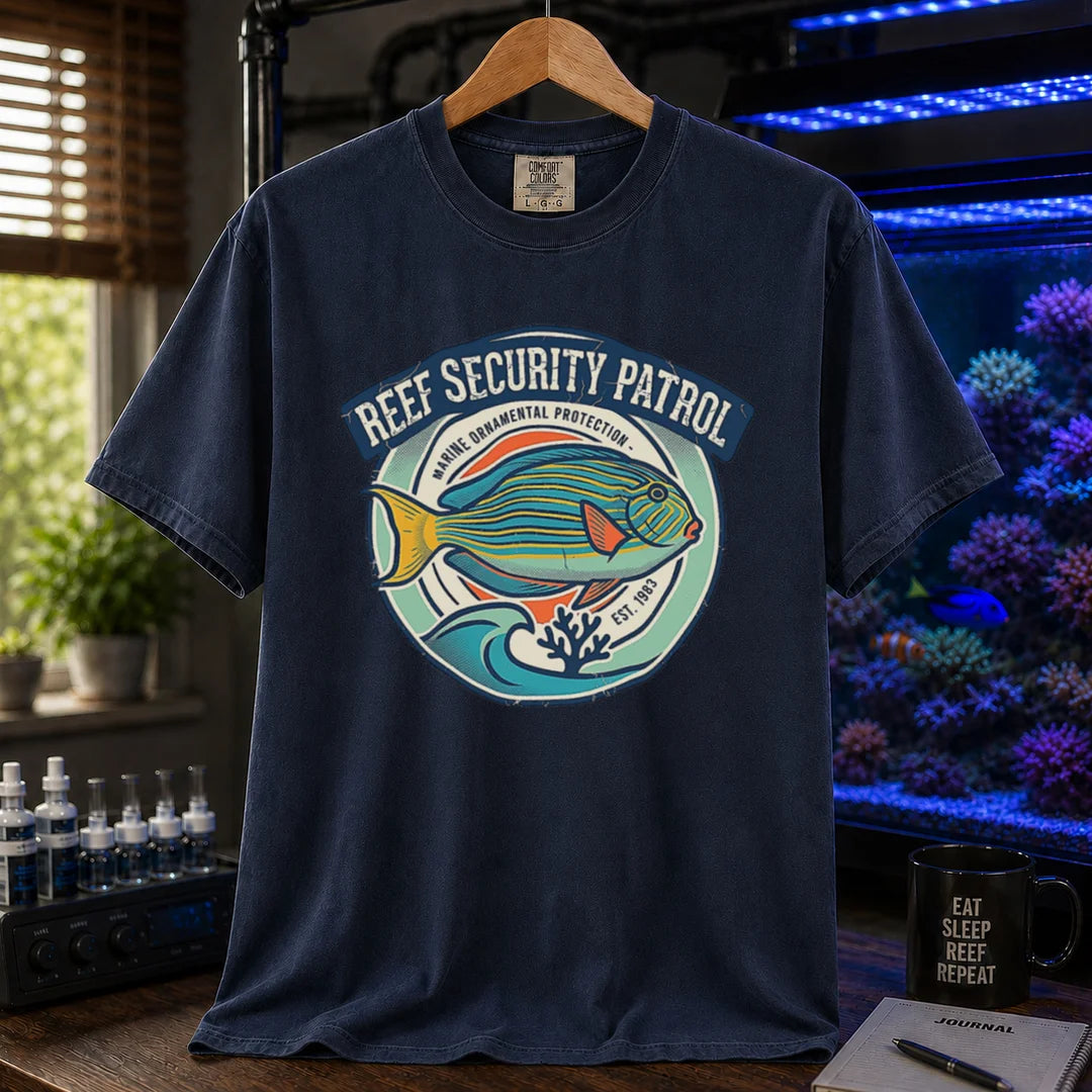 Saltwater aquarium graphic t-shirt featuring a circular emblem with a reef fish illustration and text: REEF SECURITY PATROL MARINE ORNAMENTAL PROTECTION EST. 1983, navy crew neck tee