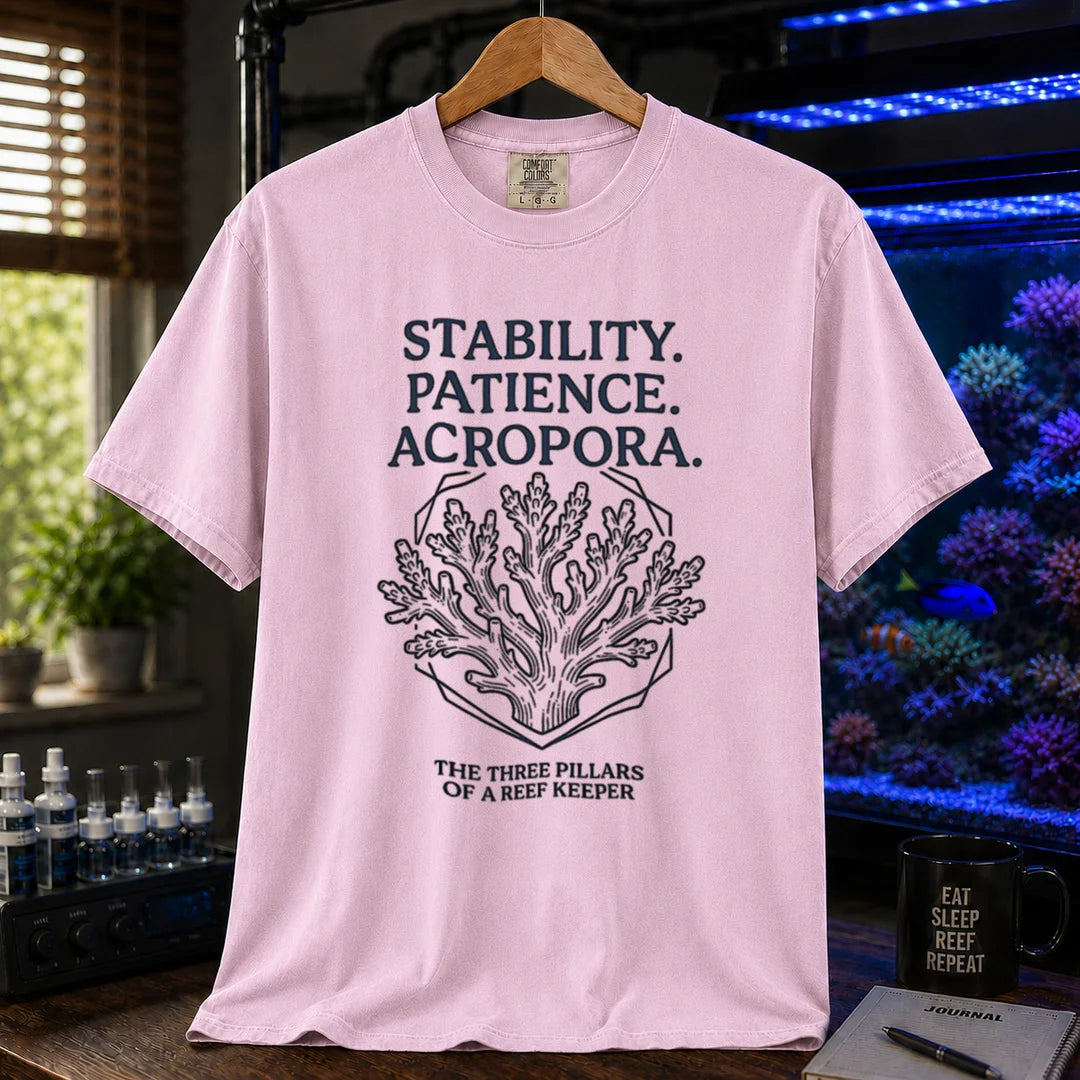 Saltwater aquarium graphic t-shirt featuring an Acropora coral illustration and text: STABILITY. PATIENCE. ACROPORA. THE THREE PILLARS OF A REEF KEEPER, pink crew neck tee