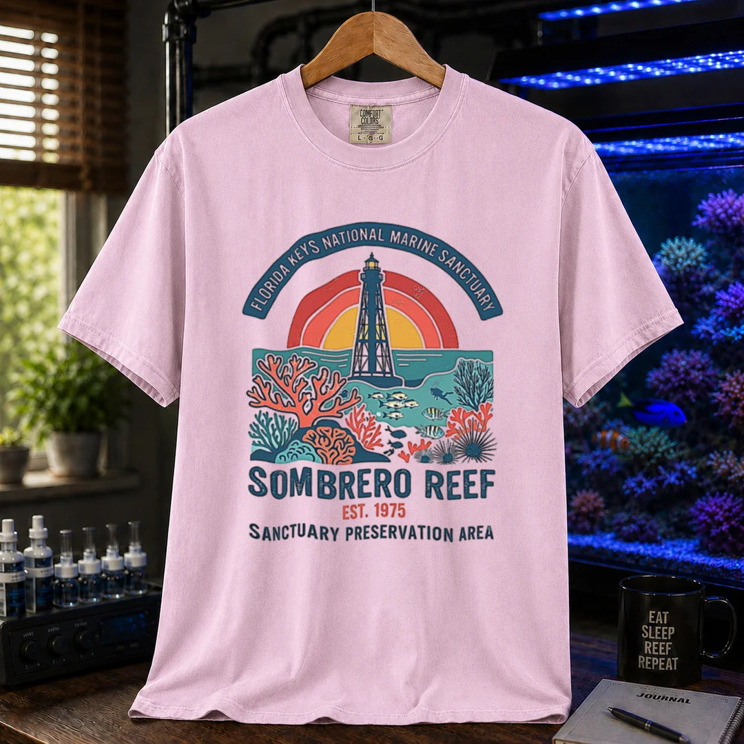 Saltwater aquarium graphic t-shirt featuring a lighthouse and coral reef illustration with text: FLORIDA KEYS NATIONAL MARINE SANCTUARY SOMBRERO REEF EST. 1975 SANCTUARY PRESERVATION AREA, pink crew neck tee