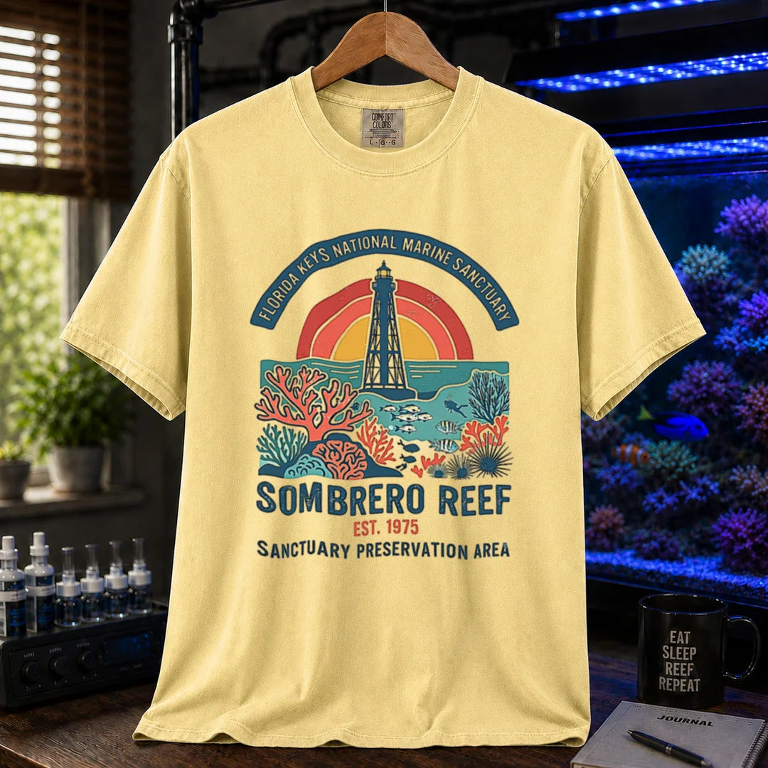 Saltwater aquarium graphic t-shirt featuring a lighthouse and coral reef illustration with text: FLORIDA KEYS NATIONAL MARINE SANCTUARY SOMBRERO REEF EST. 1975 SANCTUARY PRESERVATION AREA, butter crew neck tee