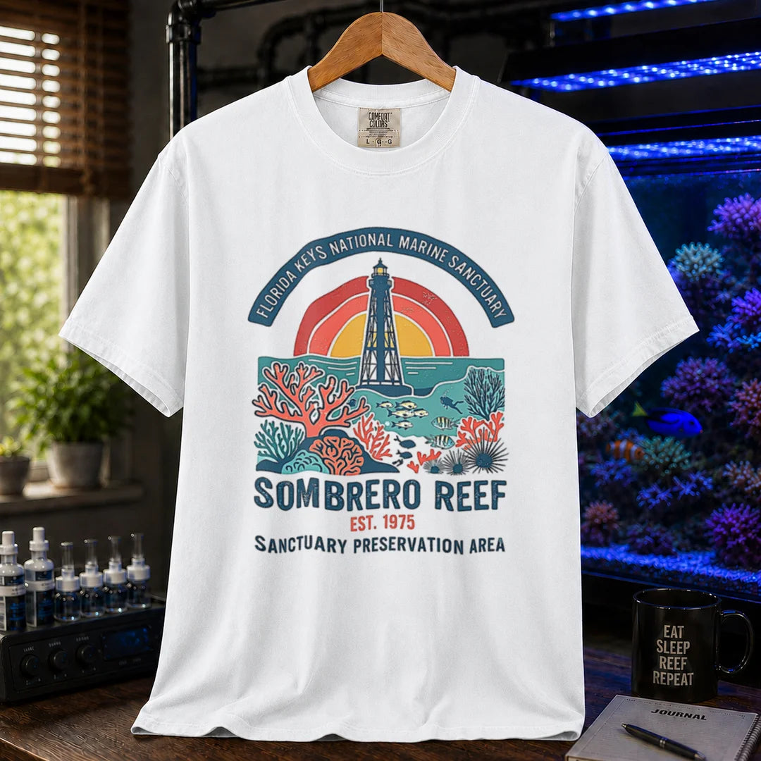 Saltwater aquarium graphic t-shirt featuring a lighthouse and coral reef illustration with text: FLORIDA KEYS NATIONAL MARINE SANCTUARY SOMBRERO REEF EST. 1975 SANCTUARY PRESERVATION AREA, white crew neck tee