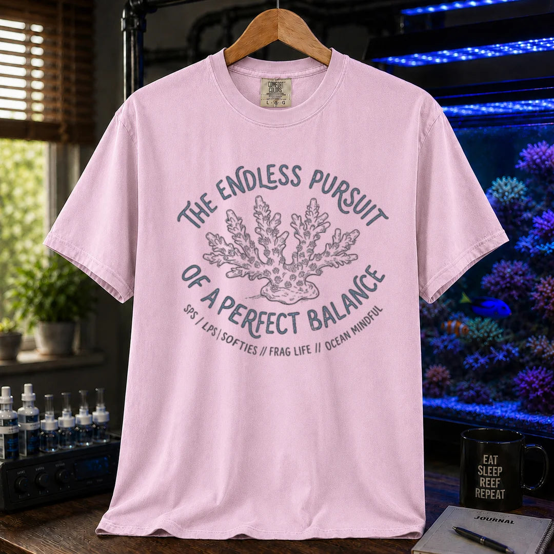 Saltwater aquarium graphic t-shirt featuring an Acropora coral illustration and text: THE ENDLESS PURSUIT OF A PERFECT BALANCE SPS / LPS / SOFTIES // FRAG LIFE // OCEAN MINDFUL, pink crew neck tee
