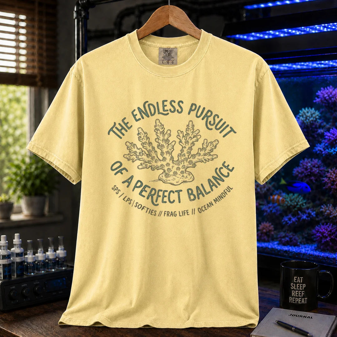 Saltwater aquarium graphic t-shirt featuring an Acropora coral illustration and text: THE ENDLESS PURSUIT OF A PERFECT BALANCE SPS / LPS / SOFTIES // FRAG LIFE // OCEAN MINDFUL, yellow crew neck tee
