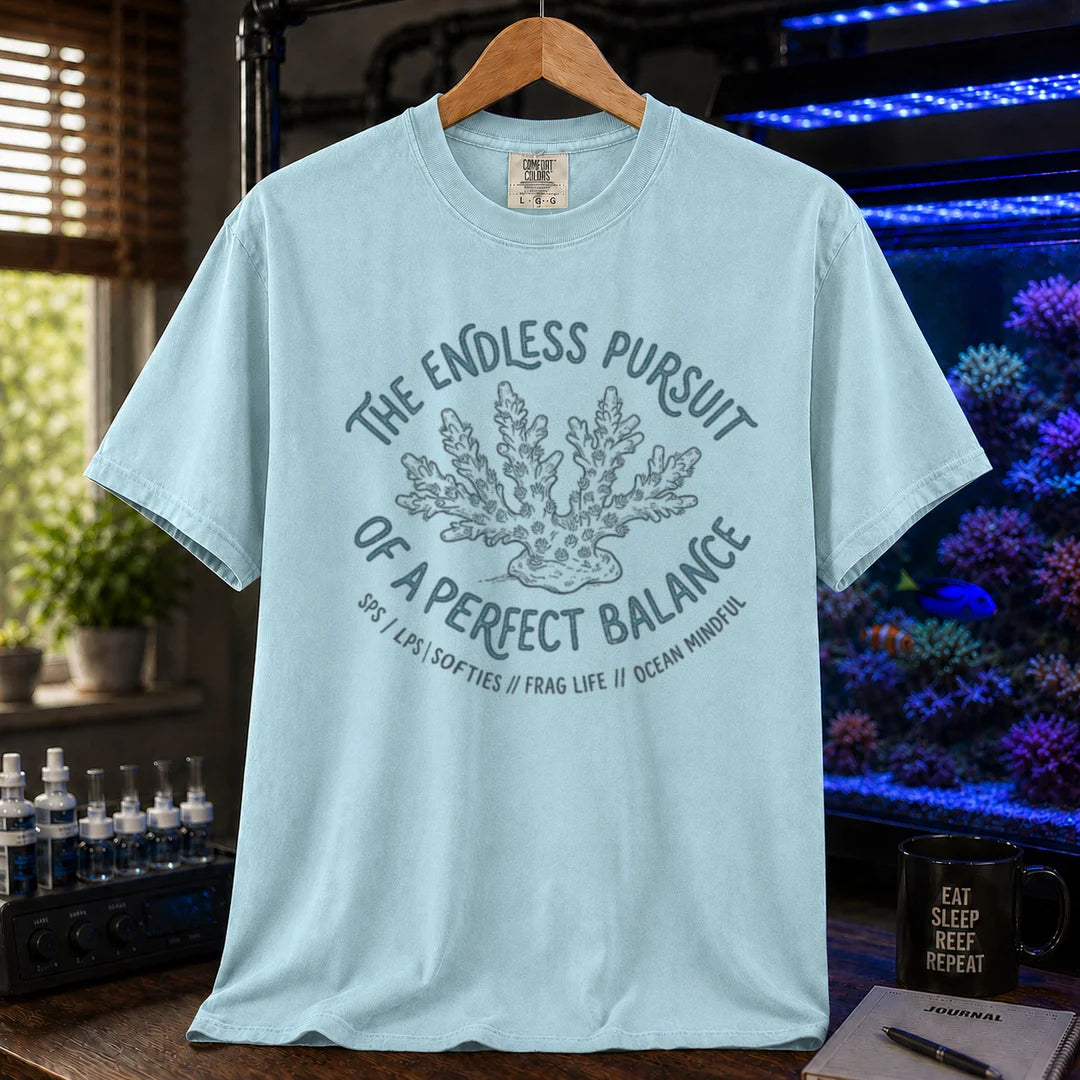 Saltwater aquarium graphic t-shirt featuring an Acropora coral illustration and text: THE ENDLESS PURSUIT OF A PERFECT BALANCE SPS / LPS / SOFTIES // FRAG LIFE // OCEAN MINDFUL, light blue crew neck tee