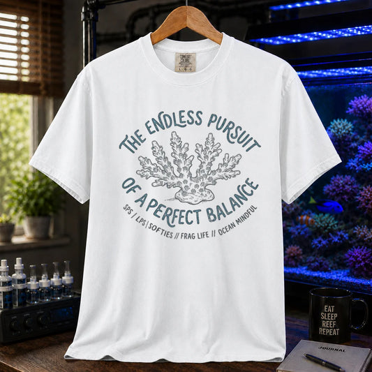 Saltwater aquarium graphic t-shirt featuring an Acropora coral illustration and text: THE ENDLESS PURSUIT OF A PERFECT BALANCE SPS / LPS / SOFTIES // FRAG LIFE // OCEAN MINDFUL, white crew neck tee