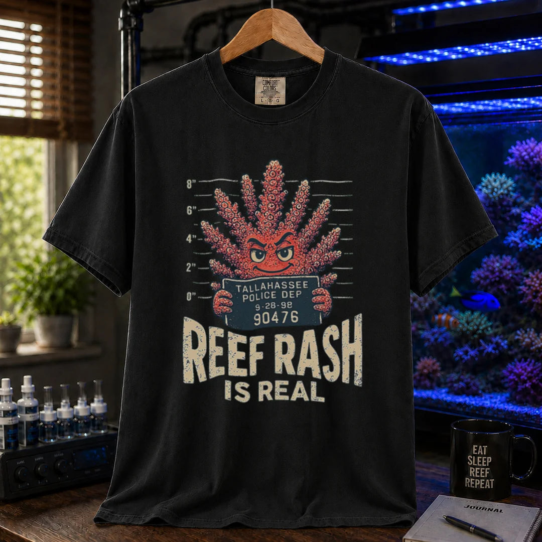 Saltwater aquarium graphic t-shirt featuring a mugshot of an anthropomorphic coral holding a police booking sign with text: REEF RASH IS REAL, black crew neck tee