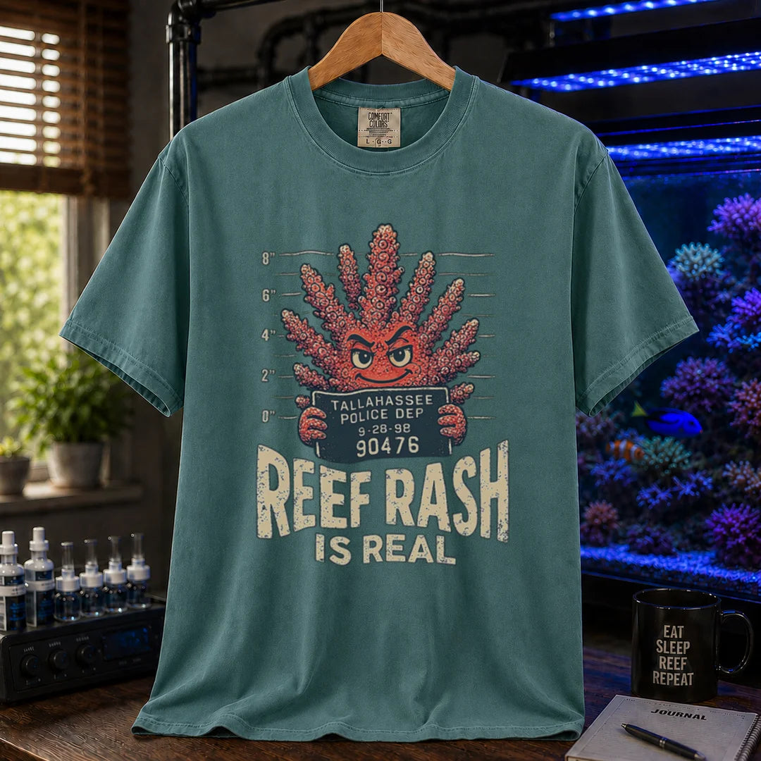Saltwater aquarium graphic t-shirt featuring a mugshot of an anthropomorphic coral holding a police booking sign with text: REEF RASH IS REAL, green crew neck tee