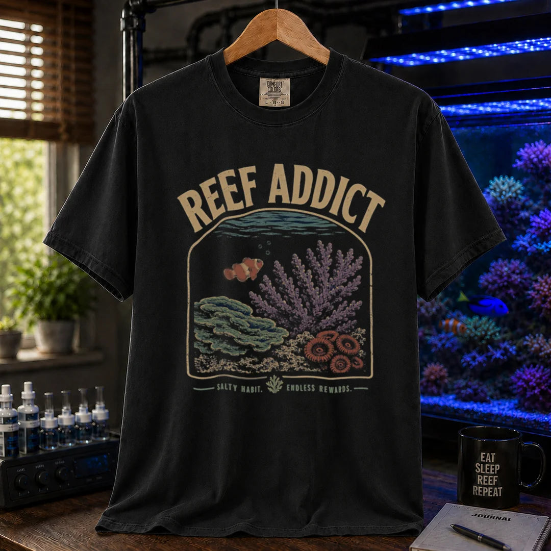 Saltwater aquarium graphic t-shirt featuring a framed reef illustration with a clownfish and text: REEF ADDICT SALTY HABIT. ENDLESS REWARDS., black crew neck tee