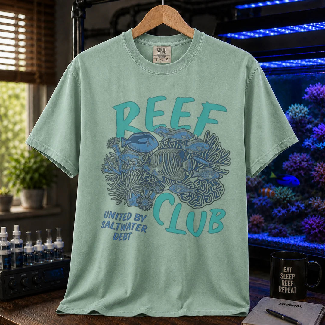 Saltwater aquarium graphic t-shirt featuring a detailed reef and fish illustration with text: REEF CLUB UNITED BY SALTWATER DEBT, green crew neck tee