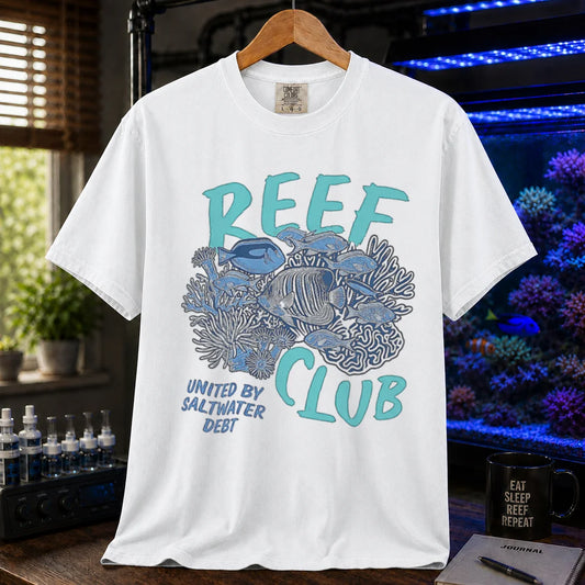 Saltwater aquarium graphic t-shirt featuring a detailed reef and fish illustration with text: REEF CLUB UNITED BY SALTWATER DEBT, white crew neck tee