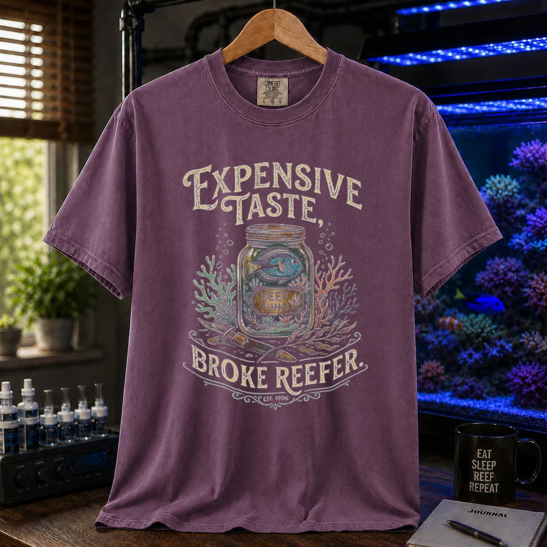 Saltwater aquarium graphic t-shirt featuring a reef fund jar illustration and text: EXPENSIVE TASTE, BROKE REEFER., purple crew neck tee