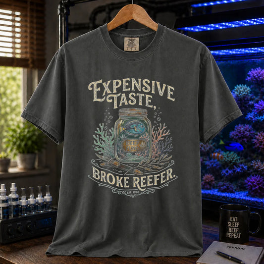 Saltwater aquarium graphic t-shirt featuring a reef fund jar illustration and text: EXPENSIVE TASTE, BROKE REEFER., dark grey crew neck tee
