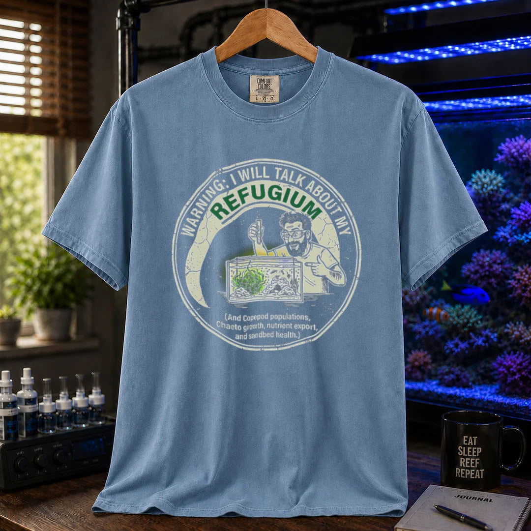 Saltwater aquarium graphic t-shirt featuring an illustration of an aquarist tending a refugium with text: WARNING: I WILL TALK ABOUT MY REFUGIUM (And Copepod populations, Chaeto growth, nutrient export, and sandbed health.), blue crew neck tee