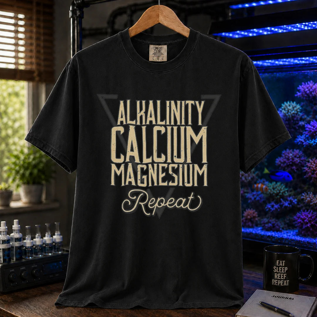 Saltwater aquarium graphic t-shirt featuring a triangle frame and text: ALKALINITY CALCIUM MAGNESIUM Repeat, black crew neck tee