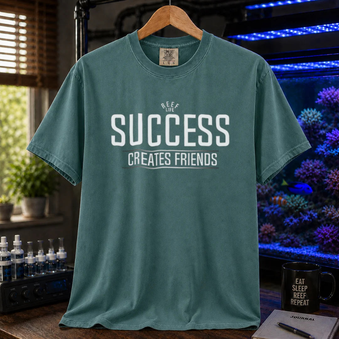 Saltwater aquarium graphic t-shirt featuring text: REEF LIFE SUCCESS CREATES FRIENDS, green crew neck tee