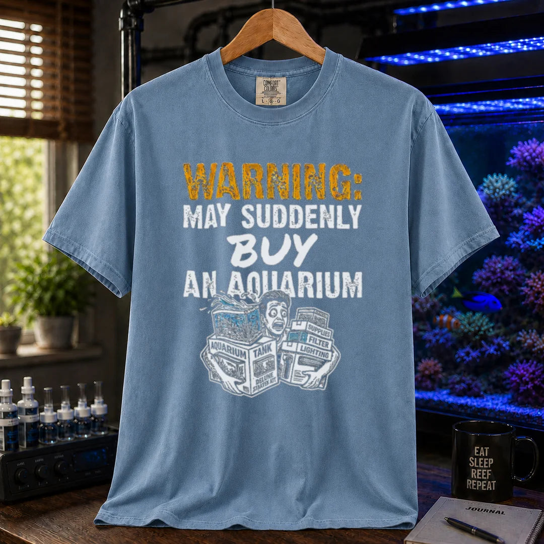 Saltwater aquarium graphic t-shirt featuring an illustration of a panicked person with tank boxes and text: WARNING: MAY SUDDENLY BUY AN AQUARIUM, blue crew neck tee