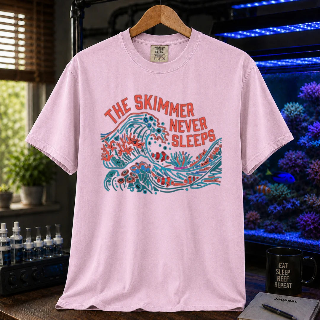 Saltwater aquarium graphic t-shirt featuring a colorful wave and reef illustration with text: THE SKIMMER NEVER SLEEPS, pink crew neck tee
