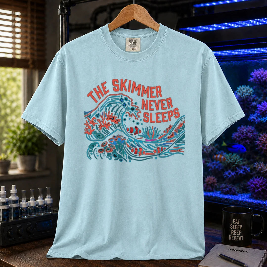 Saltwater aquarium graphic t-shirt featuring a colorful wave and reef illustration with text: THE SKIMMER NEVER SLEEPS, light blue crew neck tee
