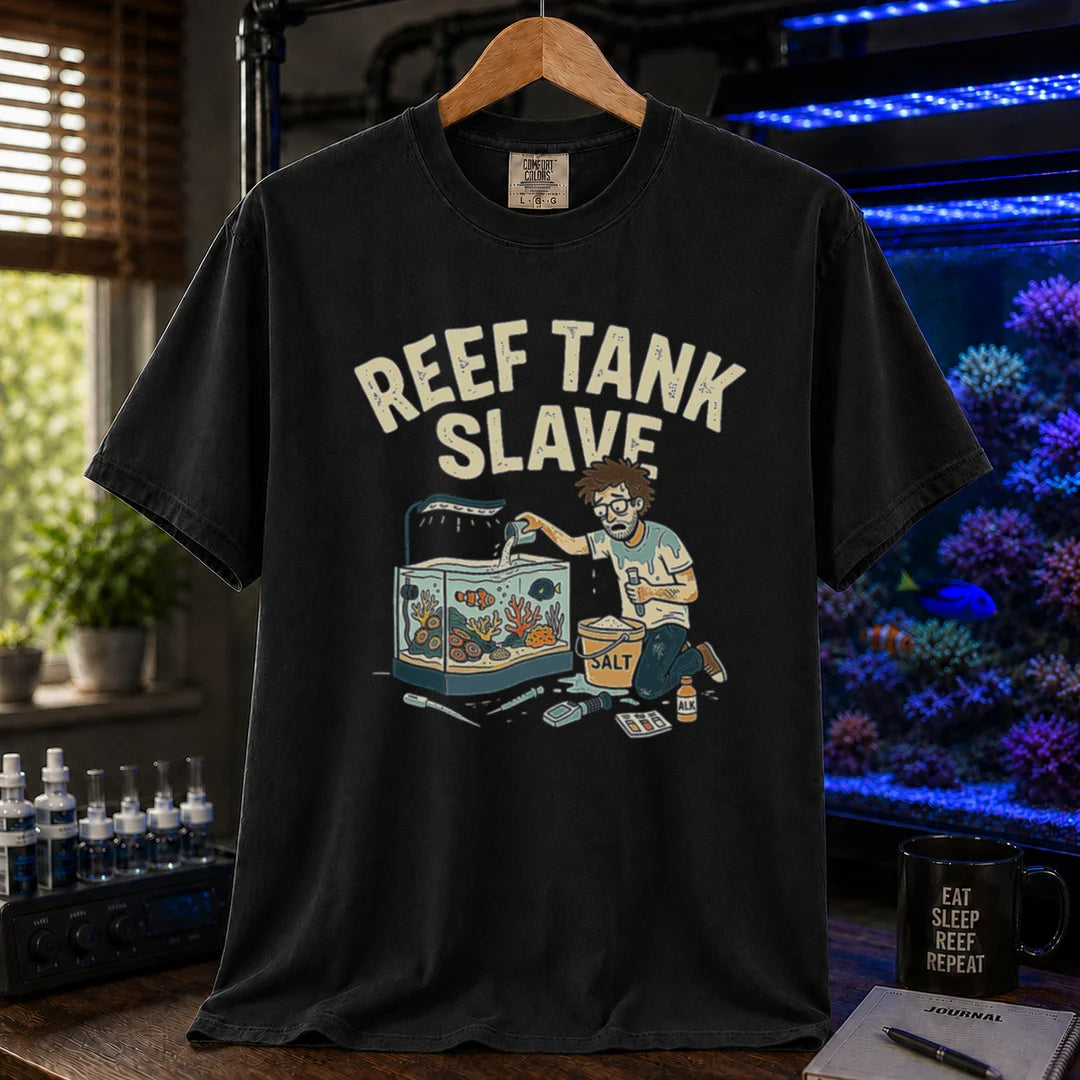 Saltwater aquarium graphic t-shirt featuring an aquarist maintaining a tank with a bucket of salt and text: REEF TANK SLAVE, black crew neck tee