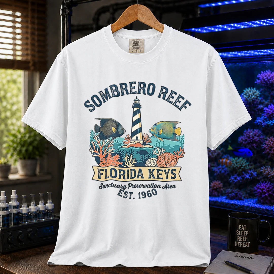 Saltwater aquarium graphic t-shirt featuring a lighthouse illustration, marine fish, and text: SOMBRERO REEF FLORIDA KEYS Sanctuary Preservation Area EST. 1960, white crew neck tee