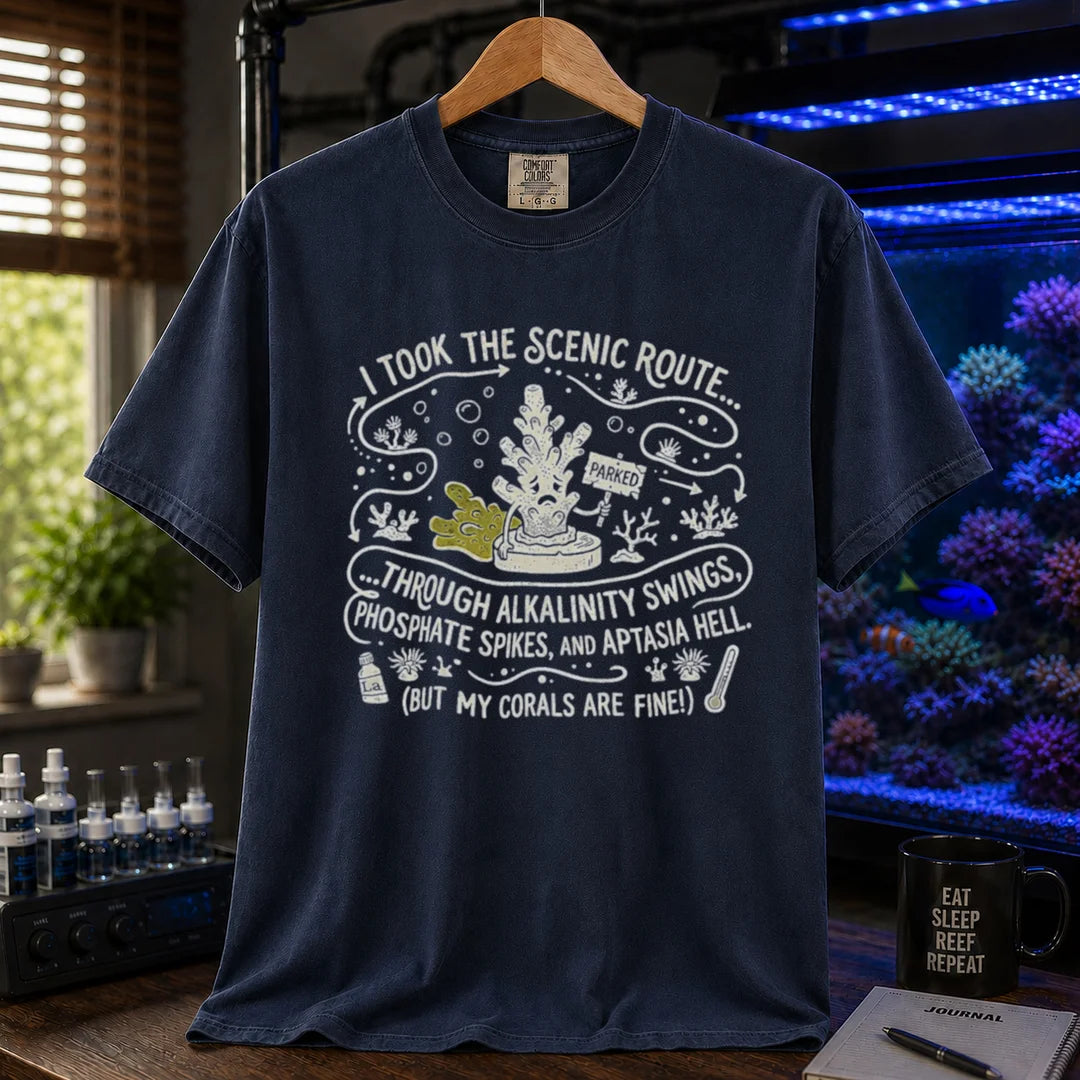 Saltwater aquarium graphic t-shirt featuring an illustrative map design with a coral character and text: I TOOK THE SCENIC ROUTE... THROUGH ALKALINITY SWINGS, PHOSPHATE SPIKES, AND APTASIA HELL. (BUT MY CORALS ARE FINE!), navy crew neck tee