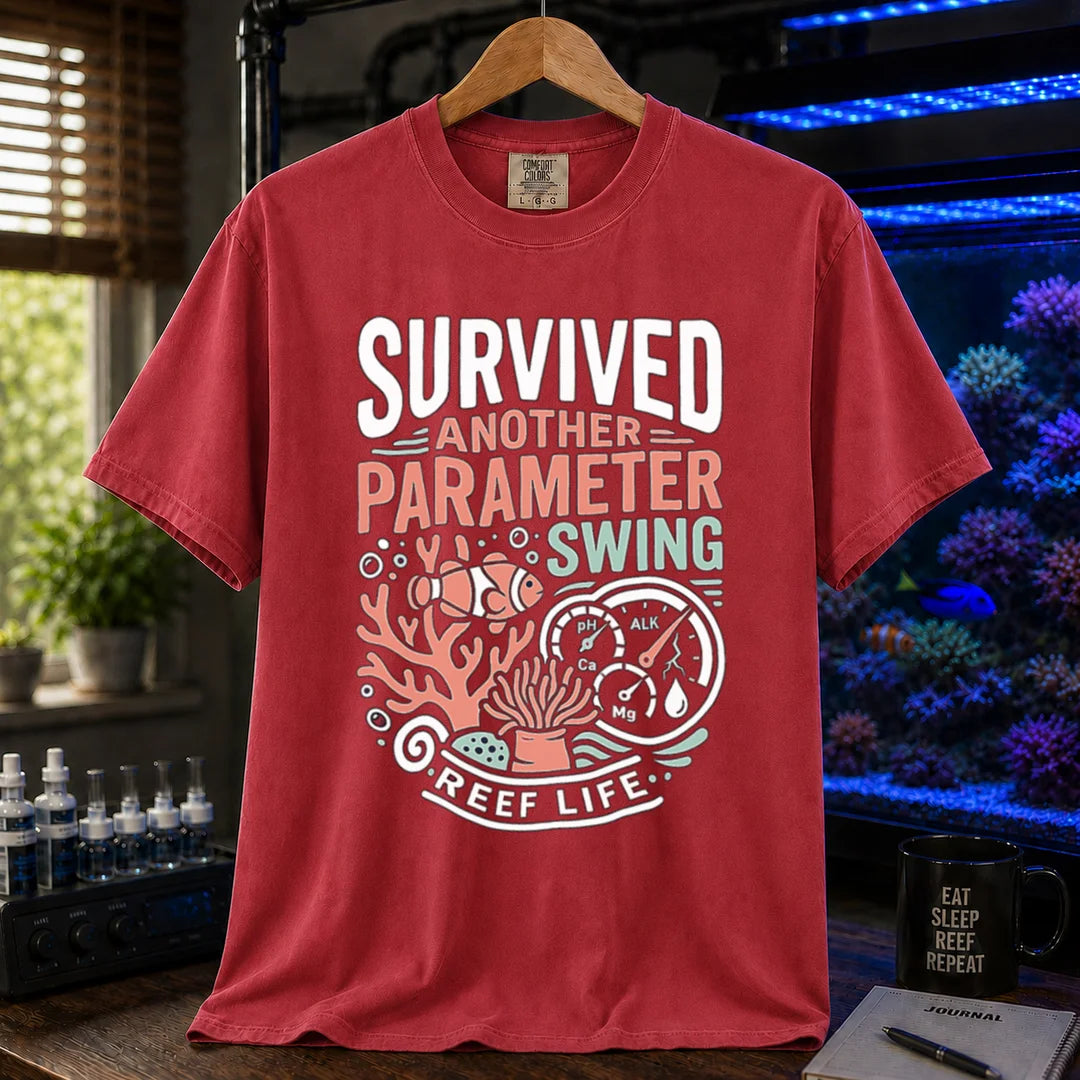 Saltwater aquarium graphic t-shirt featuring a clownfish, coral, parameter gauges, and text: SURVIVED ANOTHER PARAMETER SWING REEF LIFE, red crew neck tee