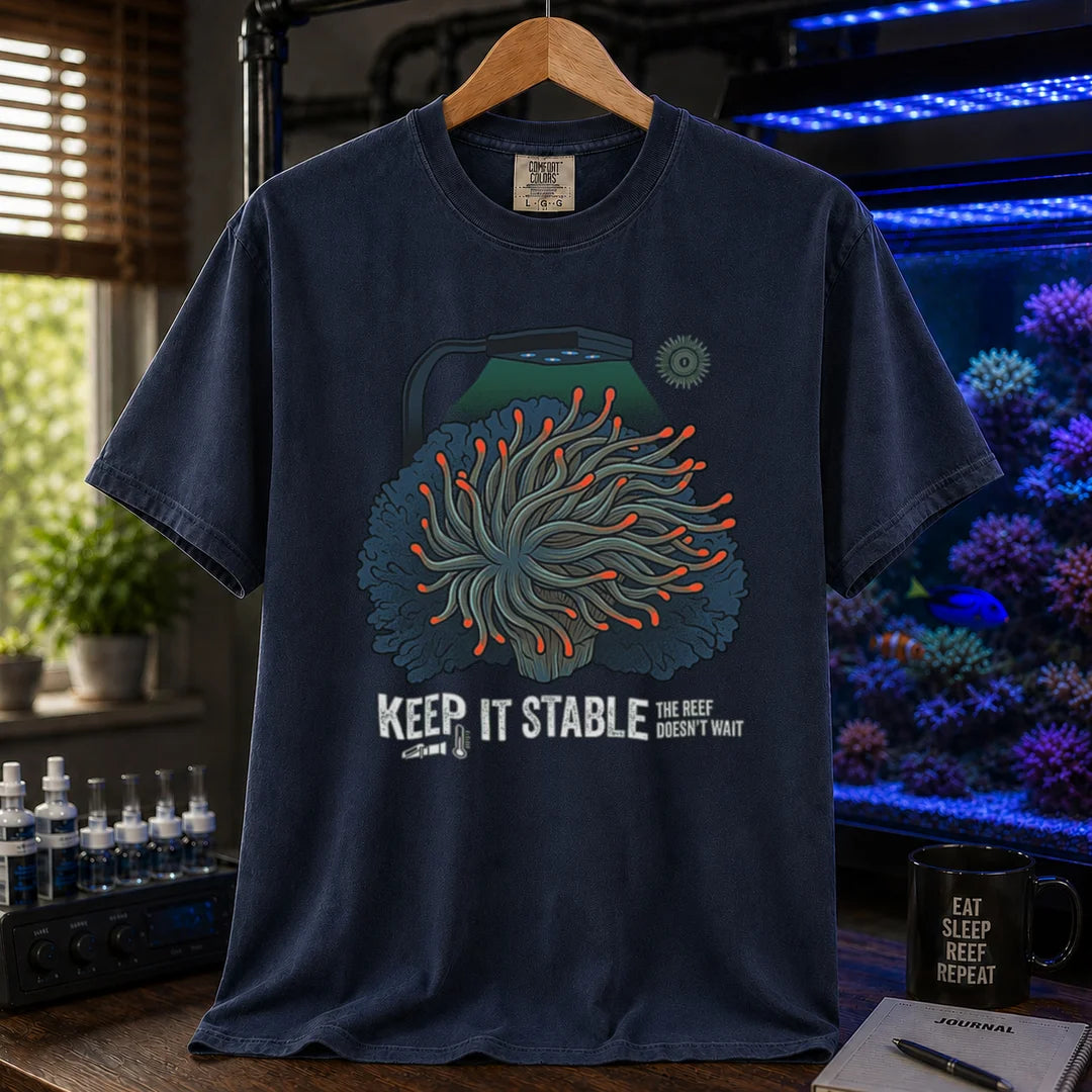 Saltwater aquarium graphic t-shirt featuring an anemone illustration under a reef light and text: KEEP IT STABLE THE REEF DOESN'T WAIT, navy crew neck tee