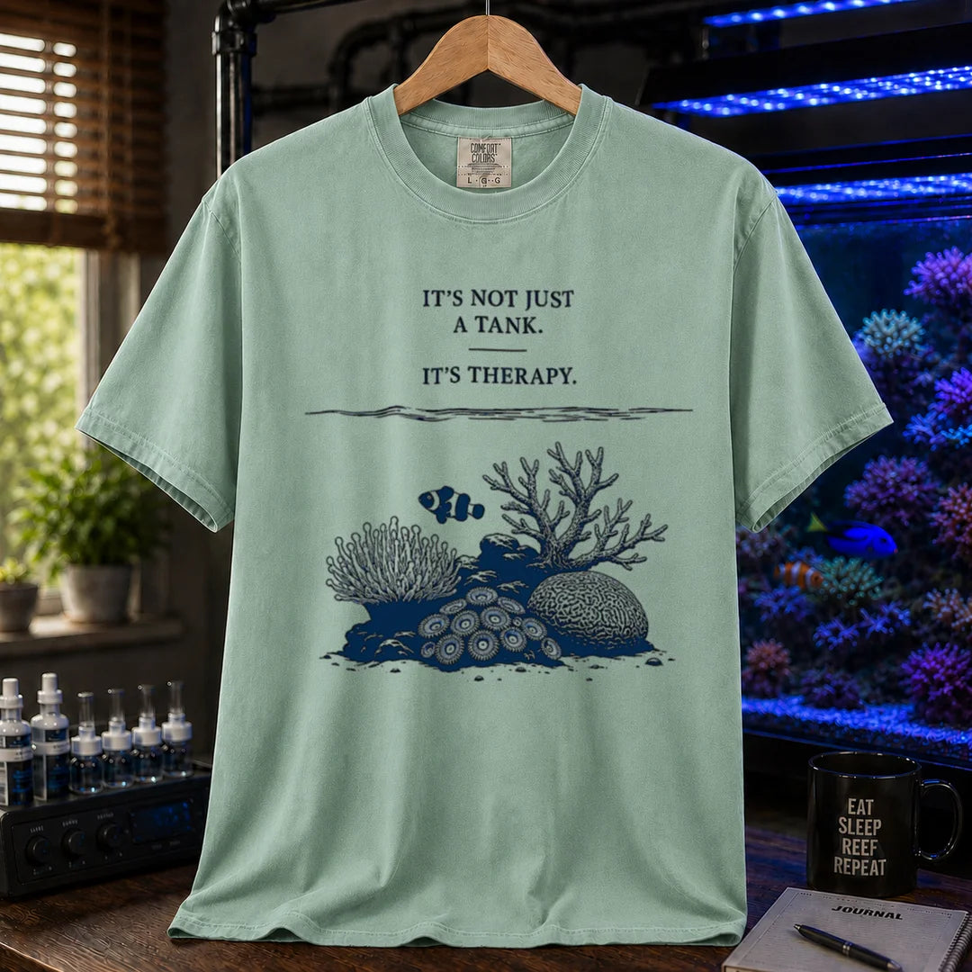 Saltwater aquarium graphic t-shirt featuring an underwater reef scene with a clownfish and text: IT'S NOT JUST A TANK. IT'S THERAPY., green crew neck tee