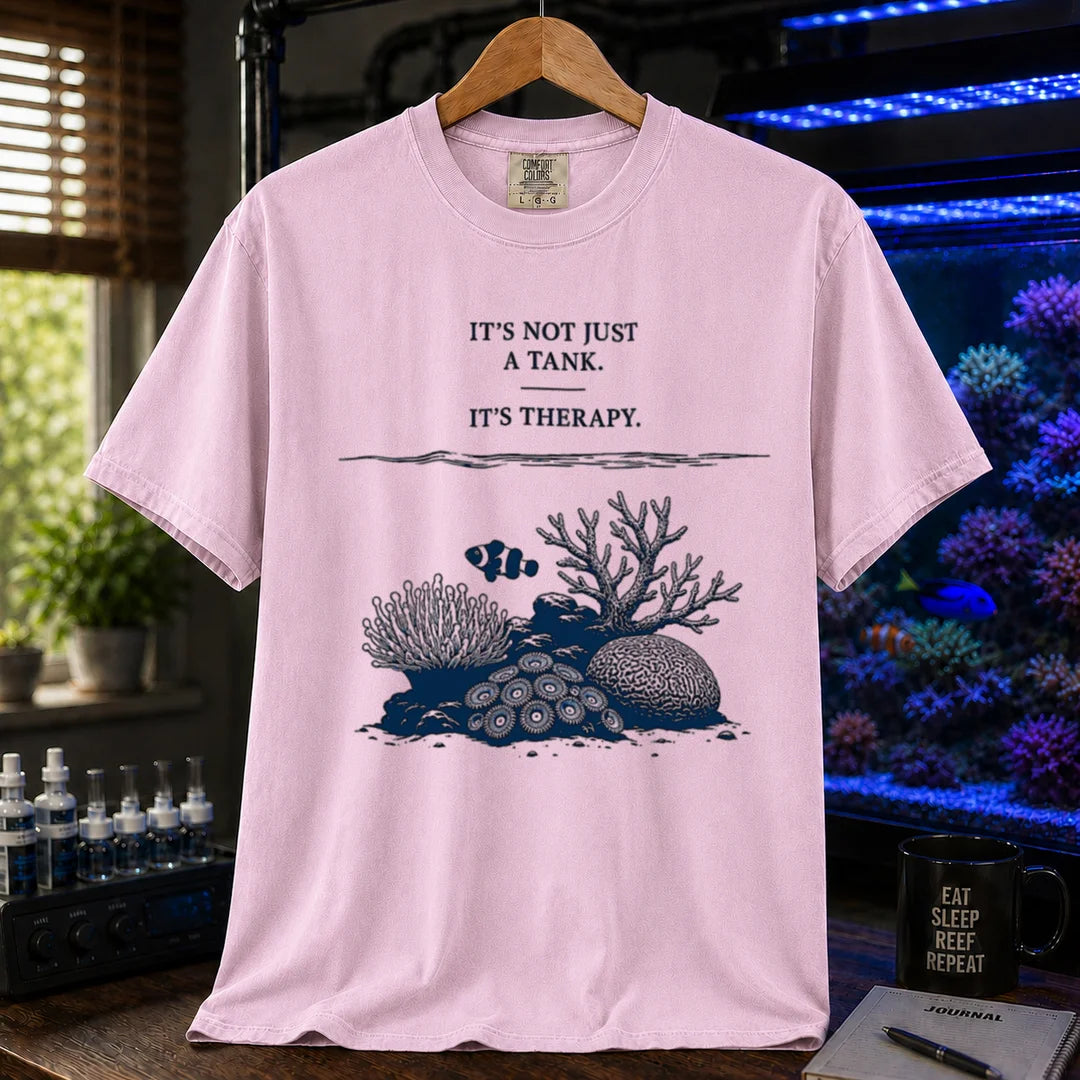 Saltwater aquarium graphic t-shirt featuring an underwater reef scene with a clownfish and text: IT'S NOT JUST A TANK. IT'S THERAPY., pink crew neck tee