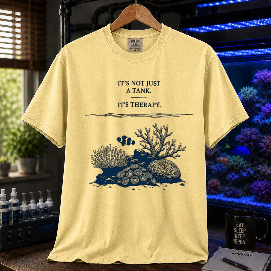 Saltwater aquarium graphic t-shirt featuring an underwater reef scene with a clownfish and text: IT'S NOT JUST A TANK. IT'S THERAPY., yellow crew neck tee