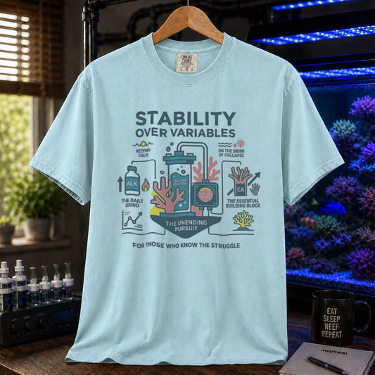 Saltwater aquarium graphic t-shirt featuring a detailed technical diagram with coral and text: STABILITY OVER VARIABLES FOR THOSE WHO KNOW THE STRUGGLE, light blue crew neck tee