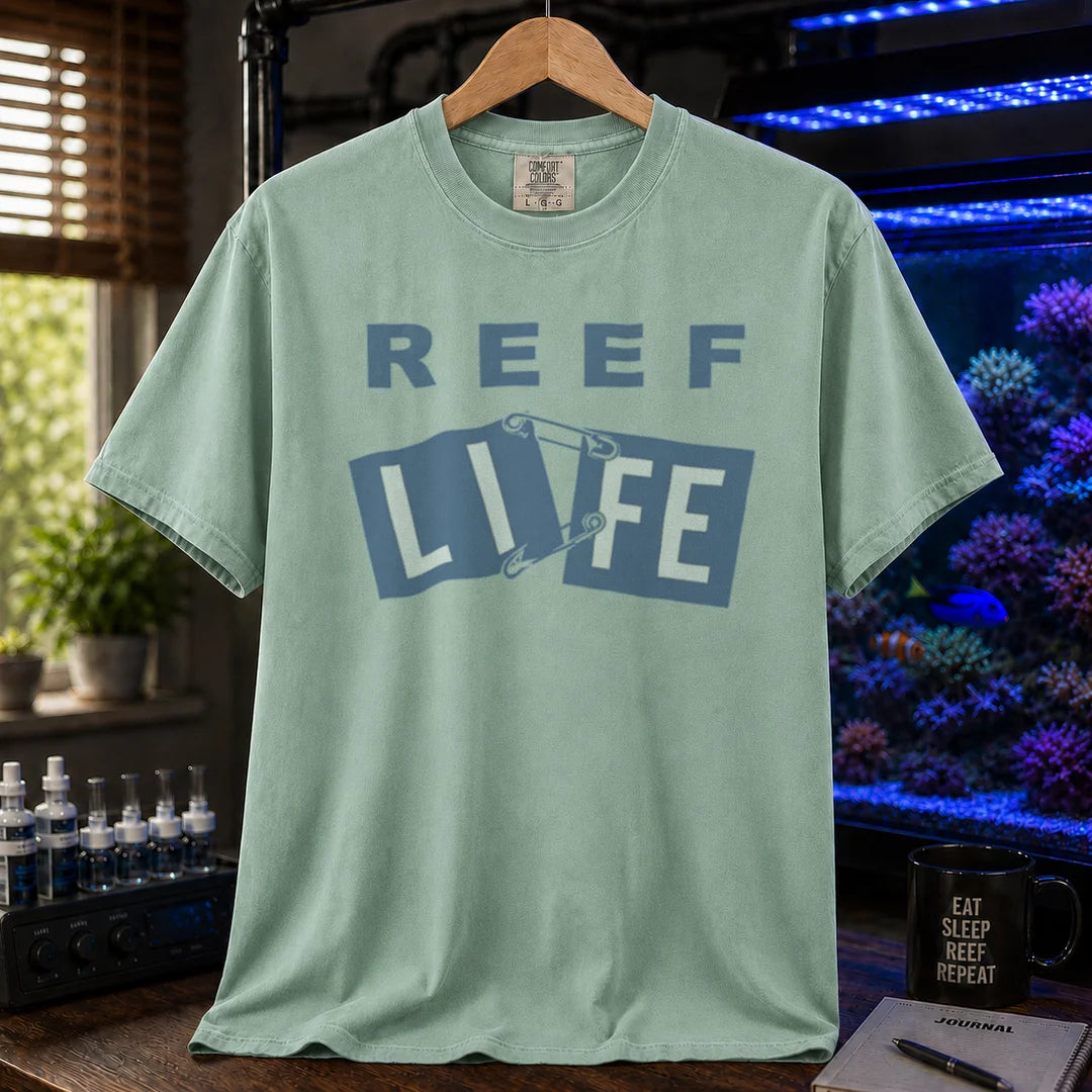 Saltwater aquarium graphic t-shirt featuring blue text reading REEF LIFE with safety pins holding the word LIFE together, green crew neck tee
