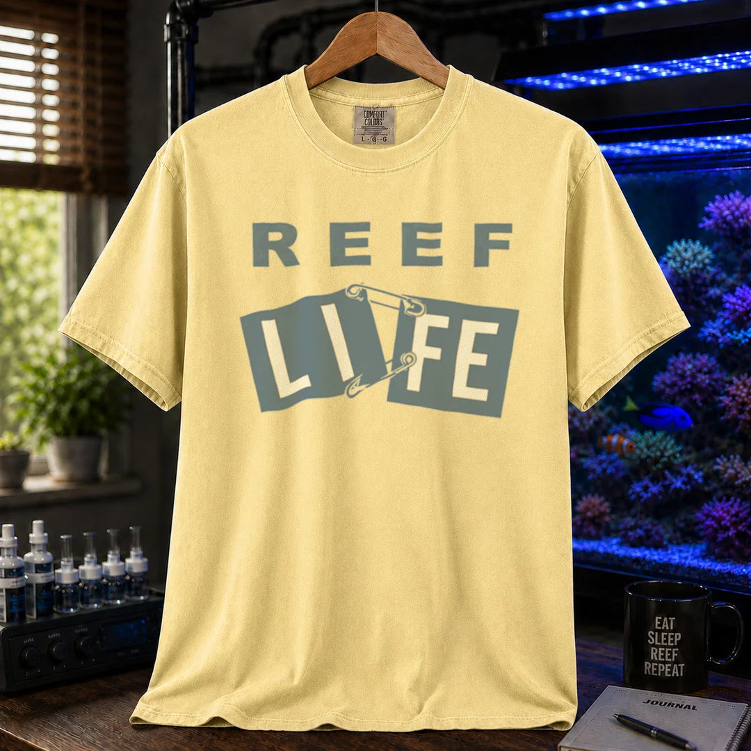 Saltwater aquarium graphic t-shirt featuring blue text reading REEF LIFE with safety pins holding the word LIFE together, yellow crew neck tee