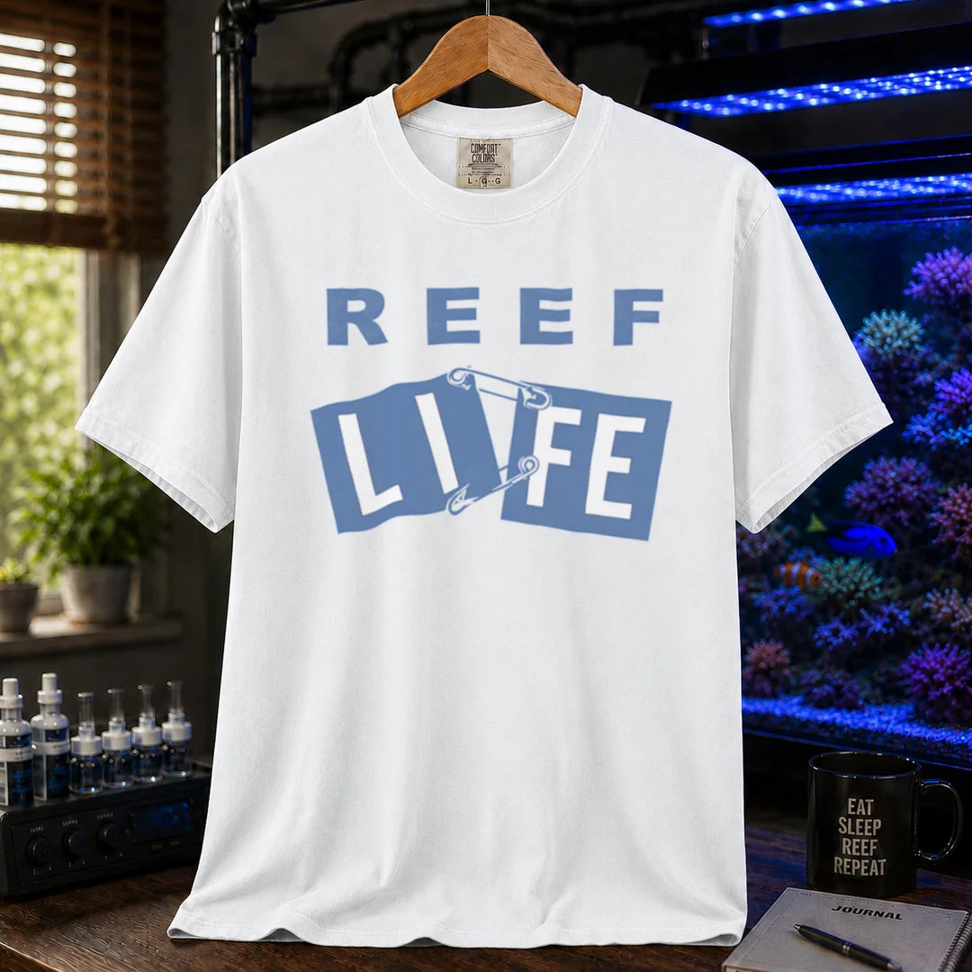 Saltwater aquarium graphic t-shirt featuring blue text reading REEF LIFE with safety pins holding the word LIFE together, white crew neck tee