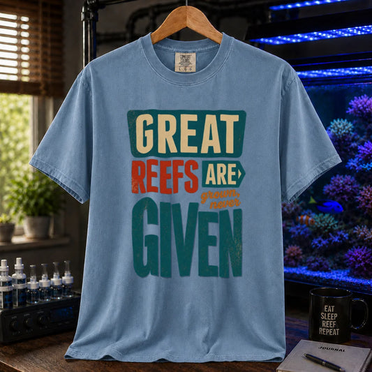 Saltwater aquarium graphic t-shirt featuring bold block text: GREAT REEFS ARE GROWN, NEVER GIVEN, blue crew neck tee