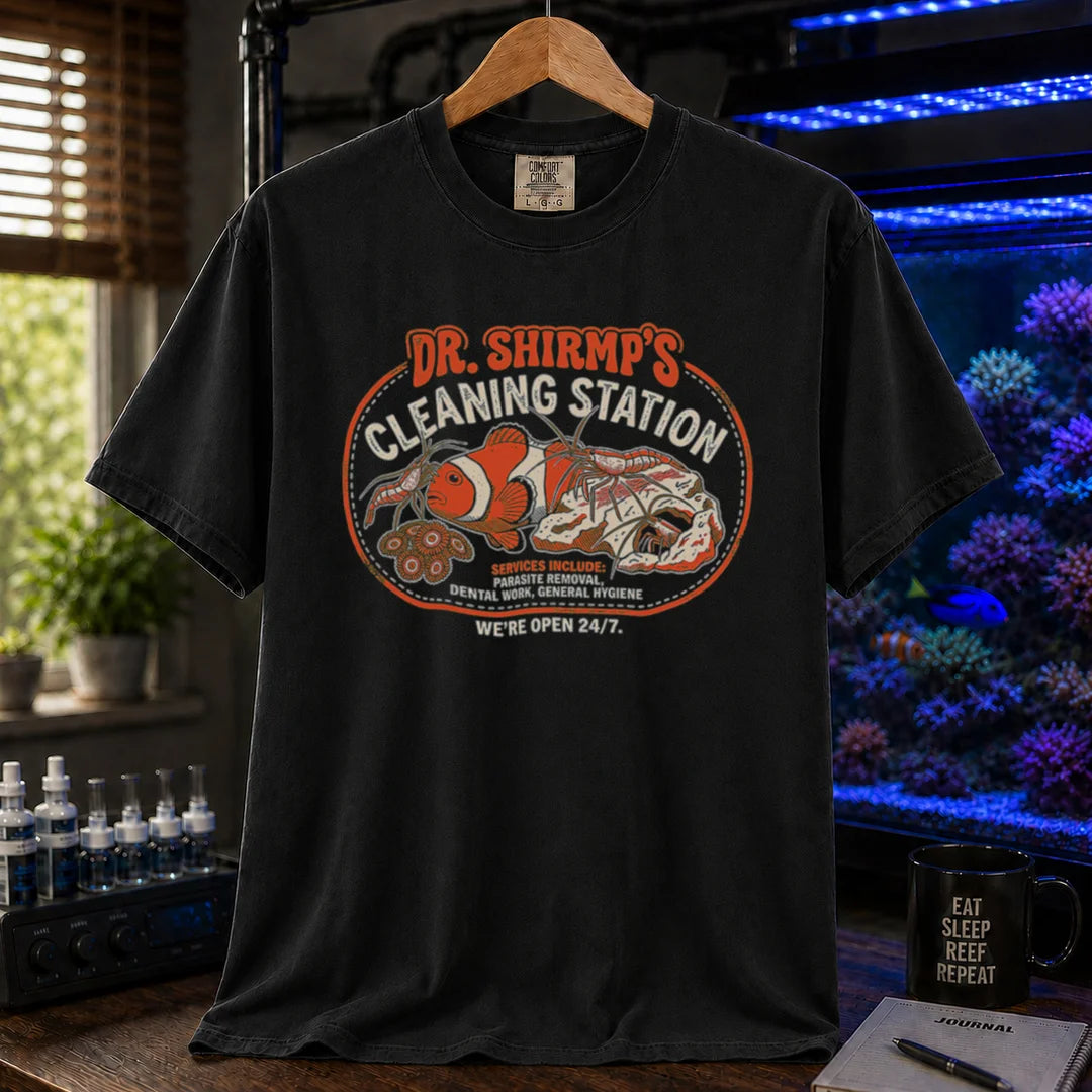 Saltwater aquarium graphic t-shirt featuring a retro badge with cleaner shrimp and text: DR. SHRIMP'S CLEANING STATION SERVICES INCLUDE: PARASITE REMOVAL, DENTAL WORK, GENERAL HYGIENE WE'RE OPEN 24/7., black crew neck tee