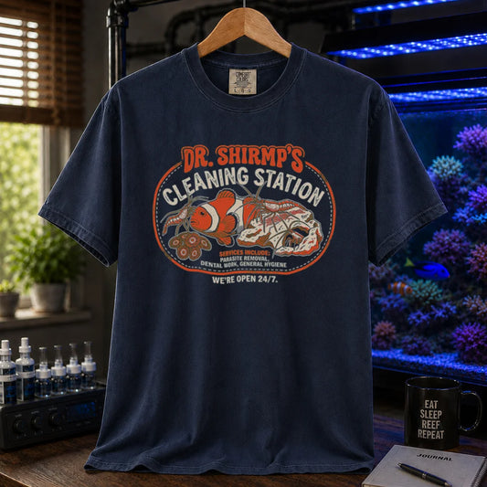Saltwater aquarium graphic t-shirt featuring a retro badge with cleaner shrimp and text: DR. SHRIMP'S CLEANING STATION SERVICES INCLUDE: PARASITE REMOVAL, DENTAL WORK, GENERAL HYGIENE WE'RE OPEN 24/7., navy crew neck tee