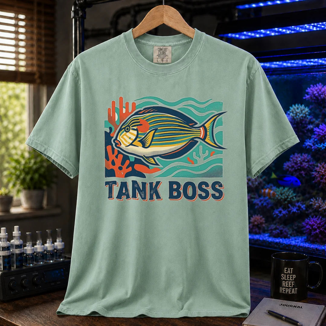 Saltwater aquarium graphic t-shirt featuring a retro illustration of a tang fish with coral and text reading TANK BOSS, green crew neck tee
