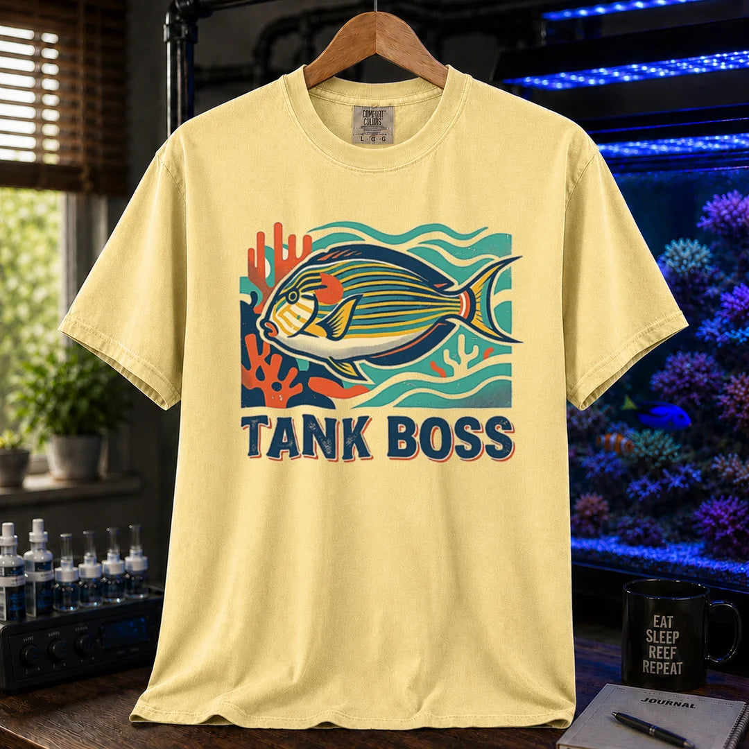Saltwater aquarium graphic t-shirt featuring a retro illustration of a tang fish with coral and text reading TANK BOSS, yellow crew neck tee