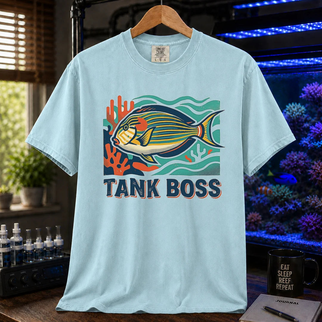 Saltwater aquarium graphic t-shirt featuring a retro illustration of a tang fish with coral and text reading TANK BOSS, light blue crew neck tee
