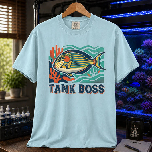 Saltwater aquarium graphic t-shirt featuring a retro illustration of a tang fish with coral and text reading TANK BOSS, light blue crew neck tee