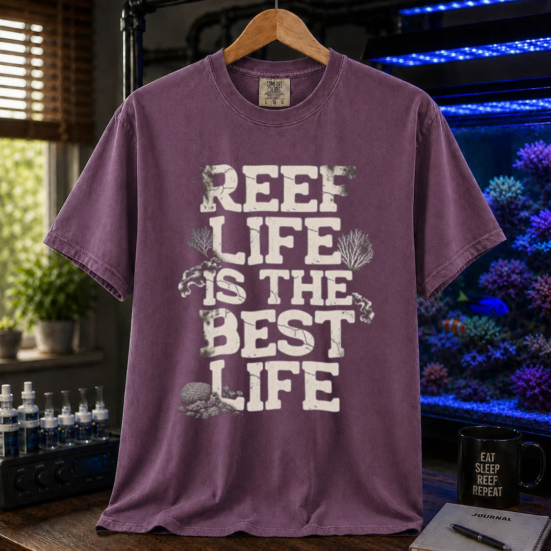 Saltwater aquarium graphic t-shirt featuring distressed white block text reading REEF LIFE IS THE BEST LIFE framed with coral illustrations, purple crew neck tee