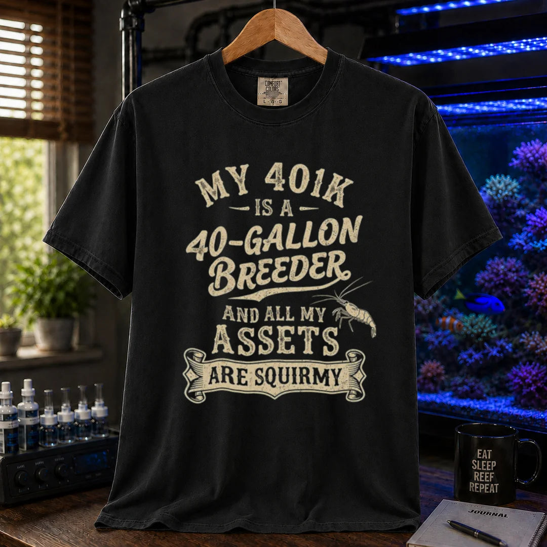 Saltwater aquarium graphic t-shirt featuring cream distressed typography reading My 401k Is A 40-Gallon Breeder And All My Assets Are Squirmy with a shrimp illustration, black crew neck tee