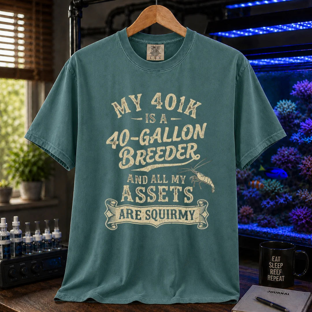 Saltwater aquarium graphic t-shirt featuring cream distressed typography reading My 401k Is A 40-Gallon Breeder And All My Assets Are Squirmy with a shrimp illustration, green crew neck tee