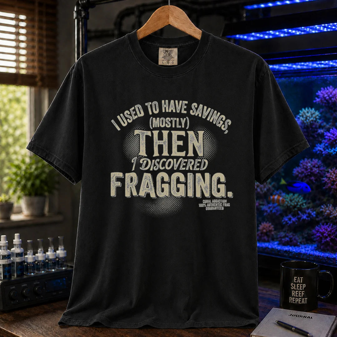 Saltwater aquarium graphic t-shirt featuring distressed cream typography reading I Used To Have Savings (Mostly) Then I Discovered Fragging with a Coral Addiction badge, black crew neck tee