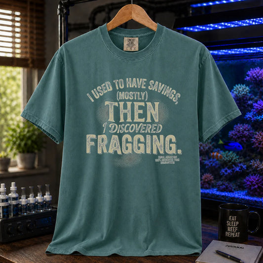 Saltwater aquarium graphic t-shirt featuring distressed cream typography reading I Used To Have Savings (Mostly) Then I Discovered Fragging with a Coral Addiction badge, green crew neck tee