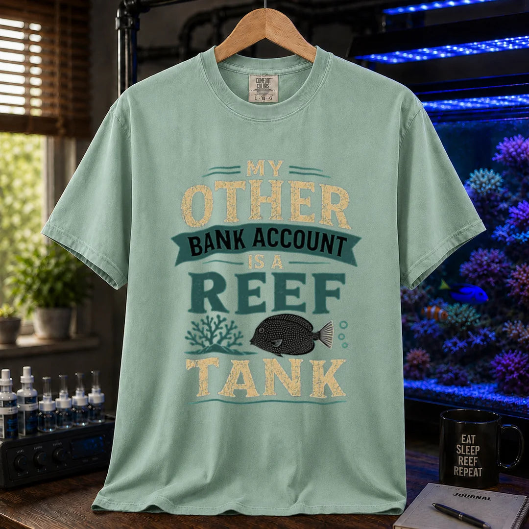 Saltwater aquarium graphic t-shirt featuring cream and teal distressed typography reading My Other Bank Account Is A Reef Tank with coral and tang illustrations, green crew neck tee