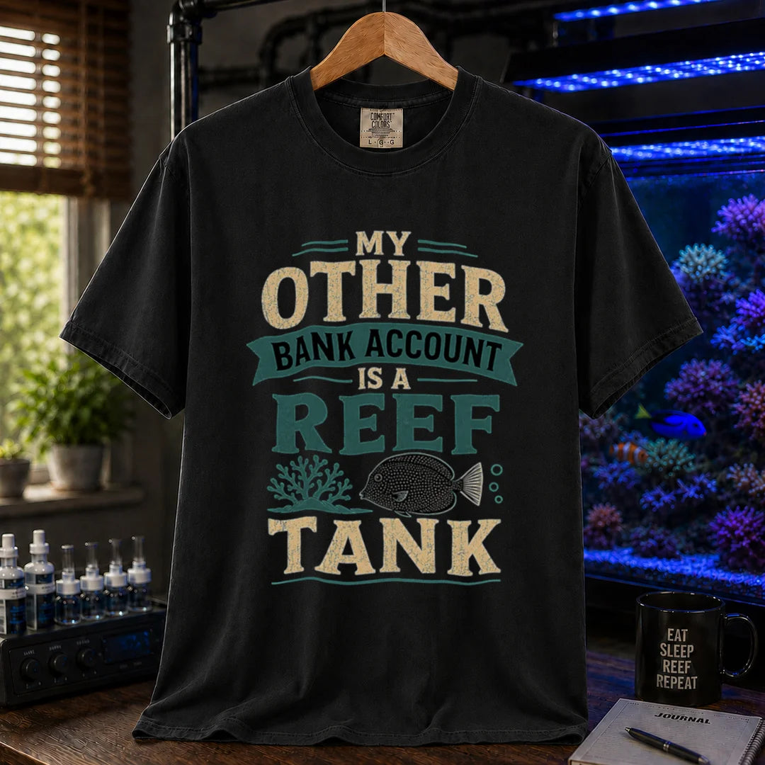 Saltwater aquarium graphic t-shirt featuring cream and teal distressed typography reading My Other Bank Account Is A Reef Tank with coral and tang illustrations, black crew neck tee
