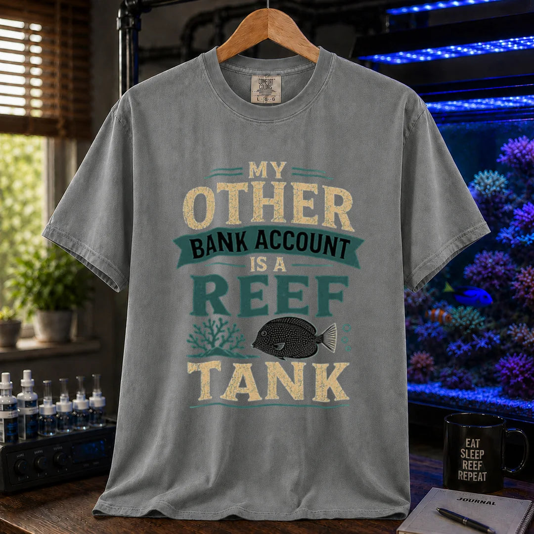 Saltwater aquarium graphic t-shirt featuring cream and teal distressed typography reading My Other Bank Account Is A Reef Tank with coral and tang illustrations, grey crew neck tee