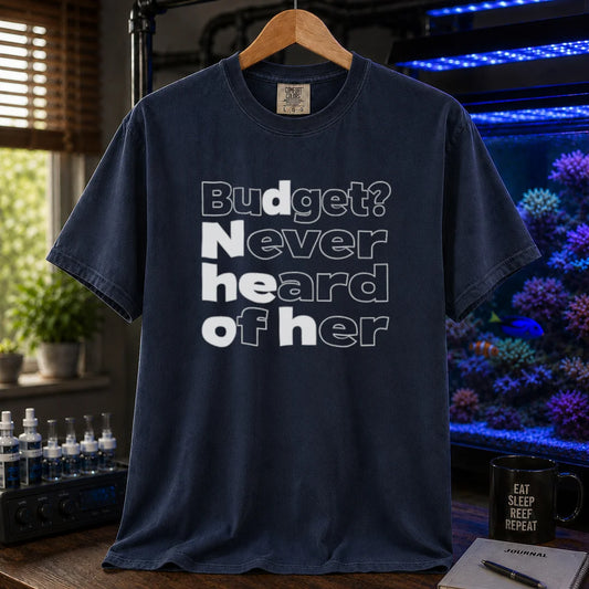 Saltwater aquarium graphic t-shirt featuring bold minimalist white typography reading Budget? Never Heard Of Her with outlined and solid letters, navy crew neck tee